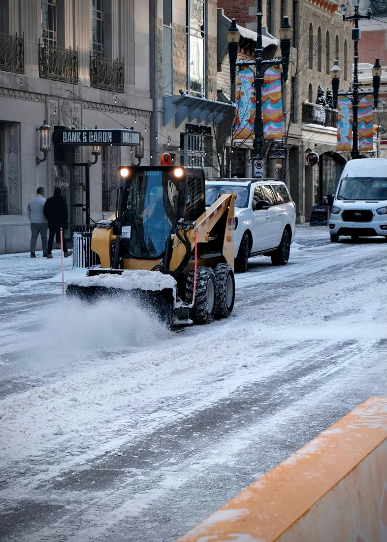 Small excavator beside an urban street